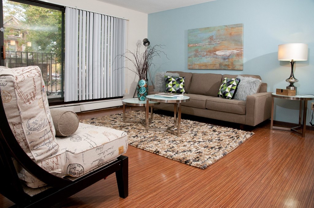 a living room with a couch and a chair and a window