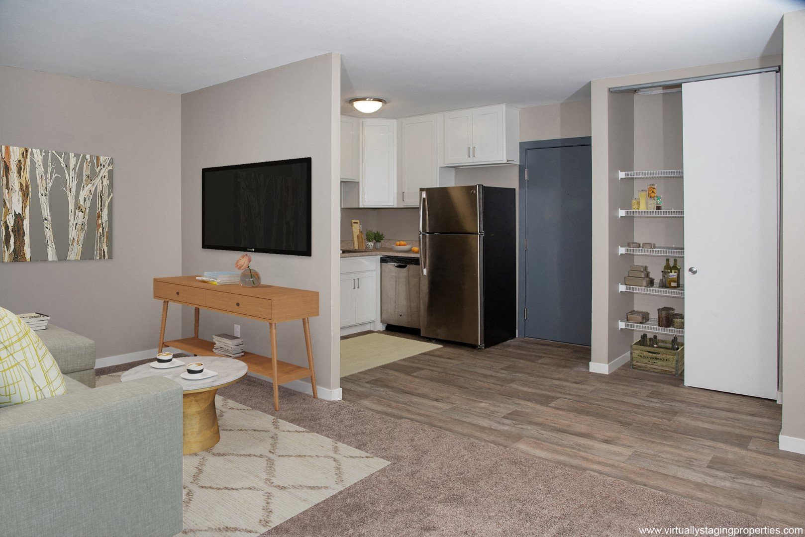 a kitchen and living room with a refrigerator and a table
