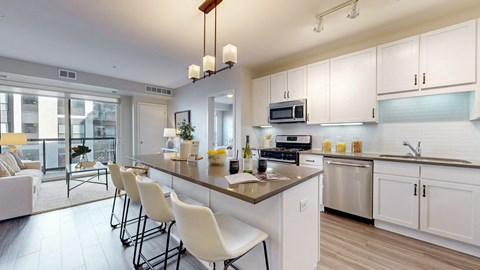 A modern kitchen with white cabinets and a large island.