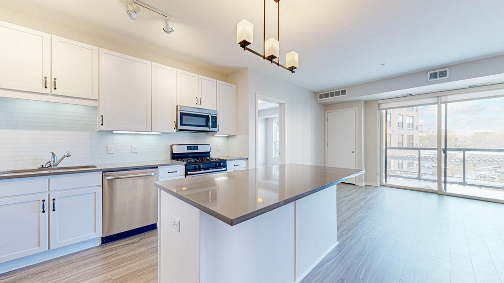 A kitchen with white cabinets and a stainless steel dishwasher.