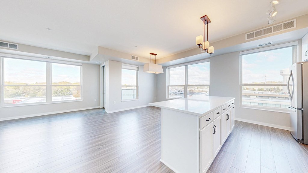 A spacious kitchen with white cabinets and a large island.
