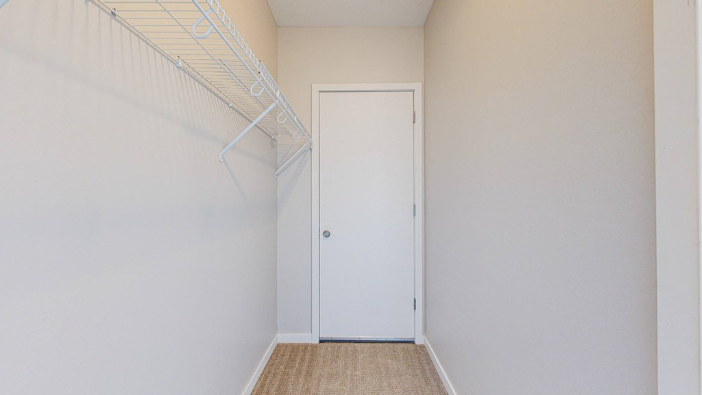 A white door is in a room with a white wall and a white ceiling.
