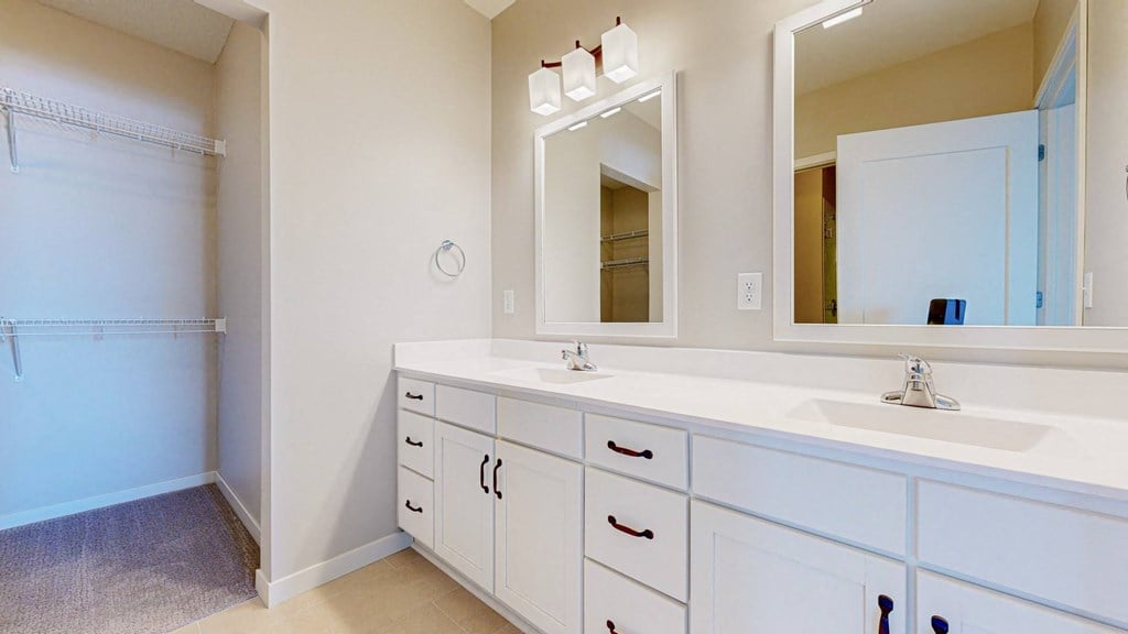 A bathroom with a sink, mirror, and cabinets.