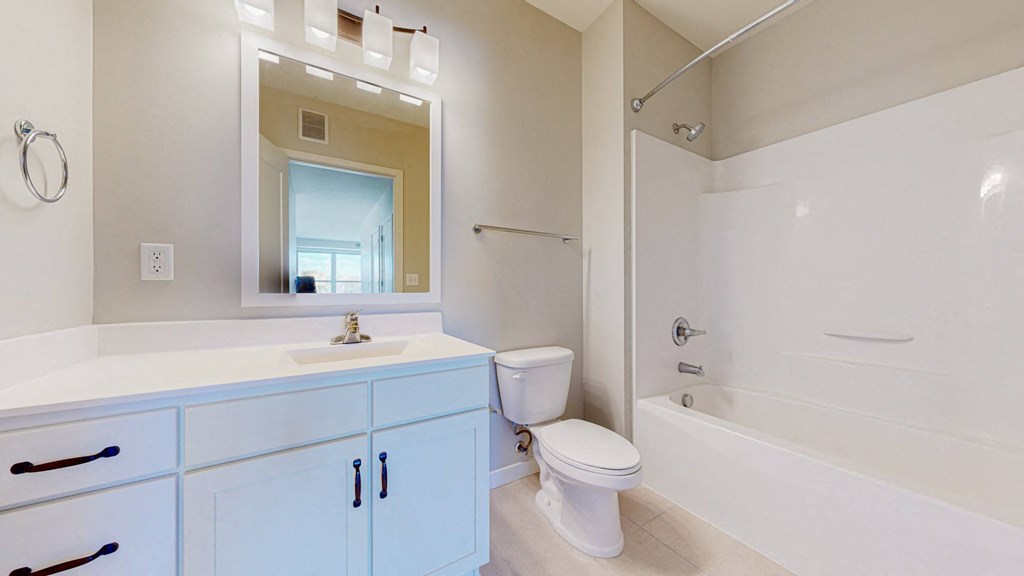 A white bathroom with a blue cabinet.