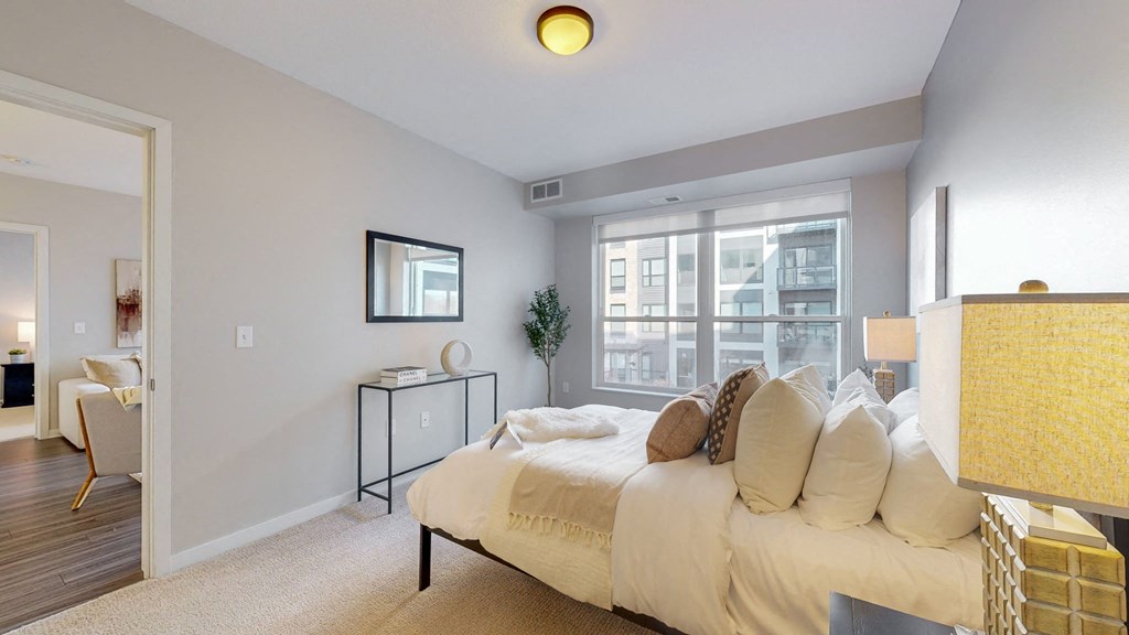 A bedroom with a bed, nightstand, and chair.