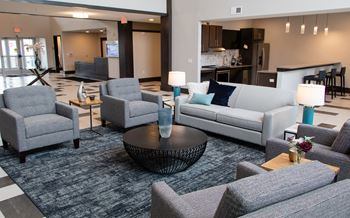 A living room with grey couches and a coffee table.at The Edison at Avonlea, Minnesota