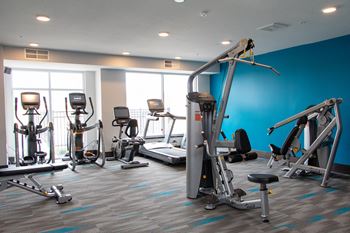 A gym with a variety of exercise equipment including treadmills, stationary bikes, and weight machines.at The Edison at Avonlea, Lakeville Minnesota