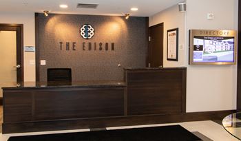 lobby with a wooden reception desk.at The Edison at Avonlea, Minnesota