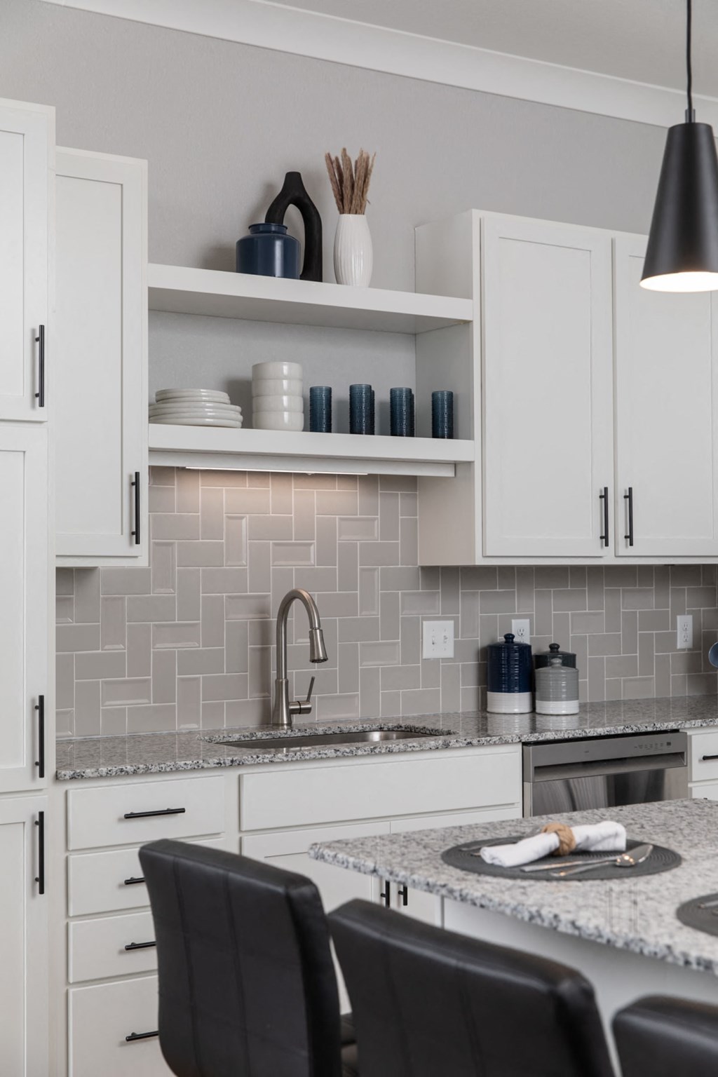 A kitchen with white cabinets and a grey backsplash. A kitchen with white cabinets and a grey backsplash.at The Edison at Maple Grove, Maple Grove, 55311