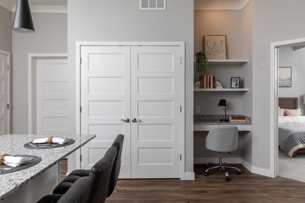 A kitchen with a table and chairs and a white door.at The Edison at Maple Grove, Maple Grove