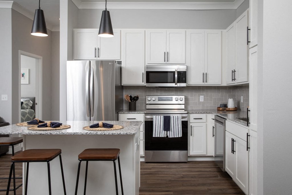 A modern kitchen with white cabinets and a stainless steel refrigerator.at The Edison at Maple Grove, Maple Grove, 55311