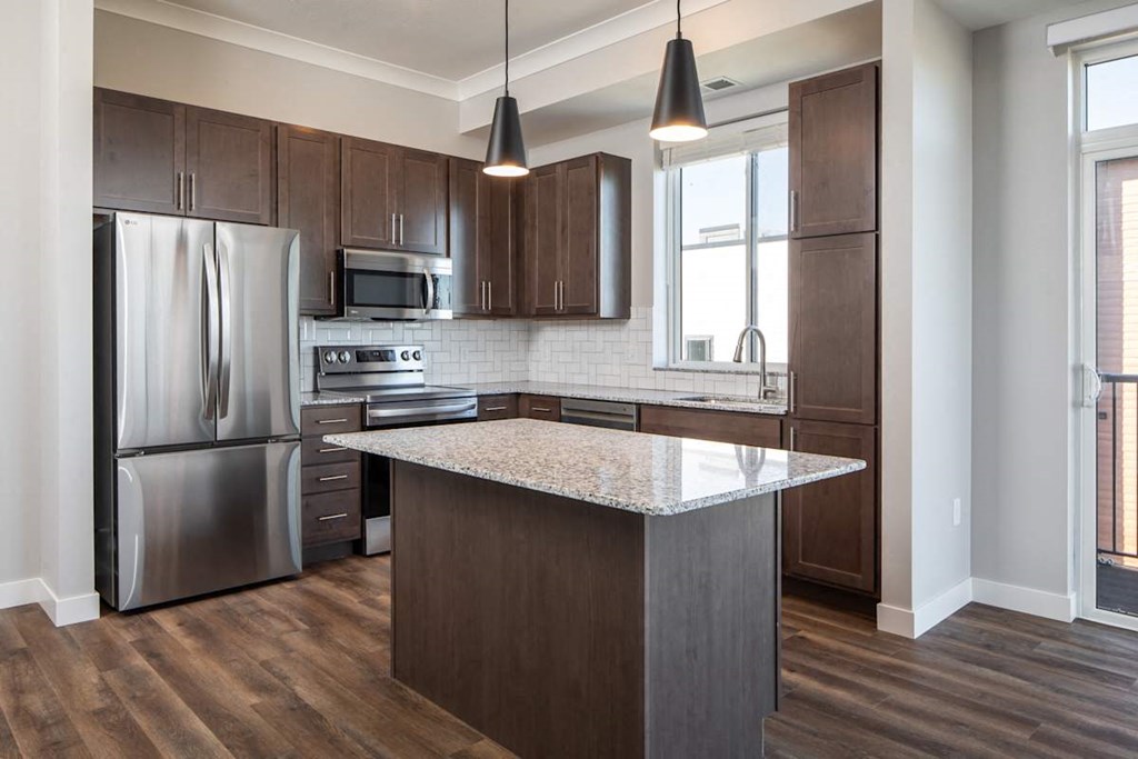 A kitchen with a refrigerator, microwave, oven, and sink.at The Edison at Maple Grove, Maple Grove, MN 55311