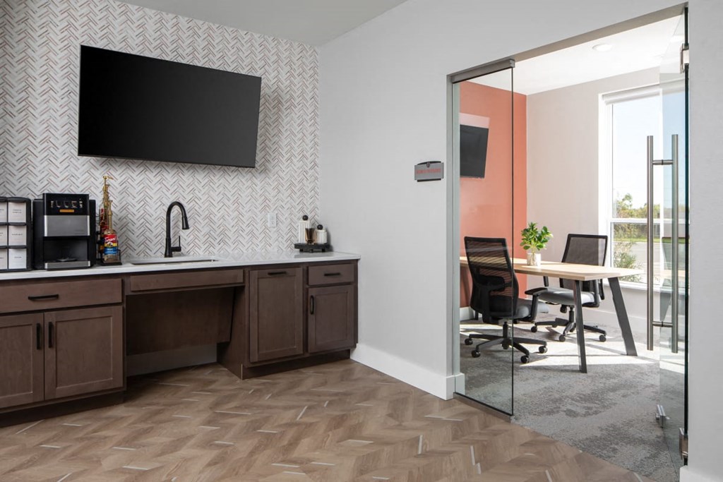 A modern kitchen with a wooden counter and a flat screen TV mounted on the wall.at The Edison at Maple Grove, Minnesota, 55311
