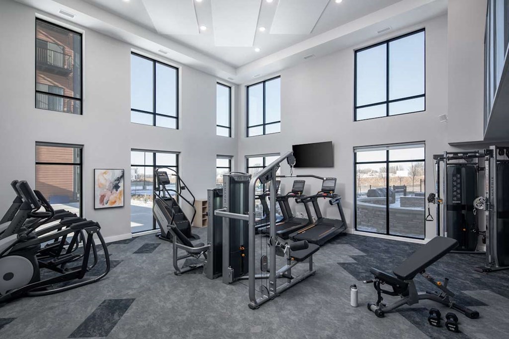 A gym with a variety of equipment including treadmills, weights, and exercise machines.at The Edison at Maple Grove, Maple Grove, MN 55311