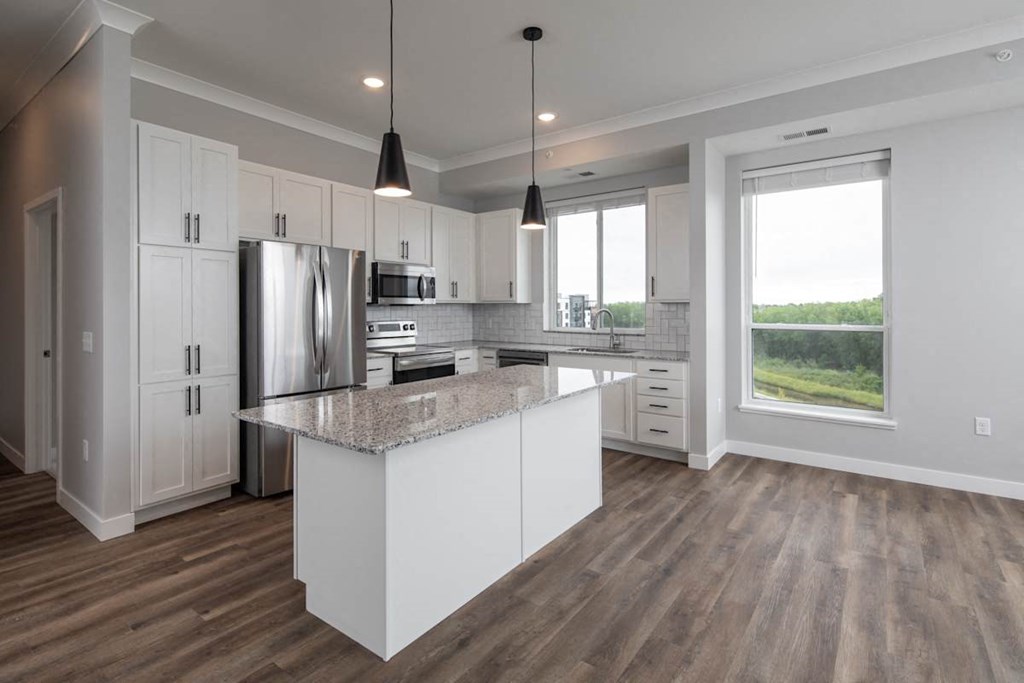 A modern kitchen with a large island and stainless steel appliances.at The Edison at Maple Grove, Maple Grove Minnesota