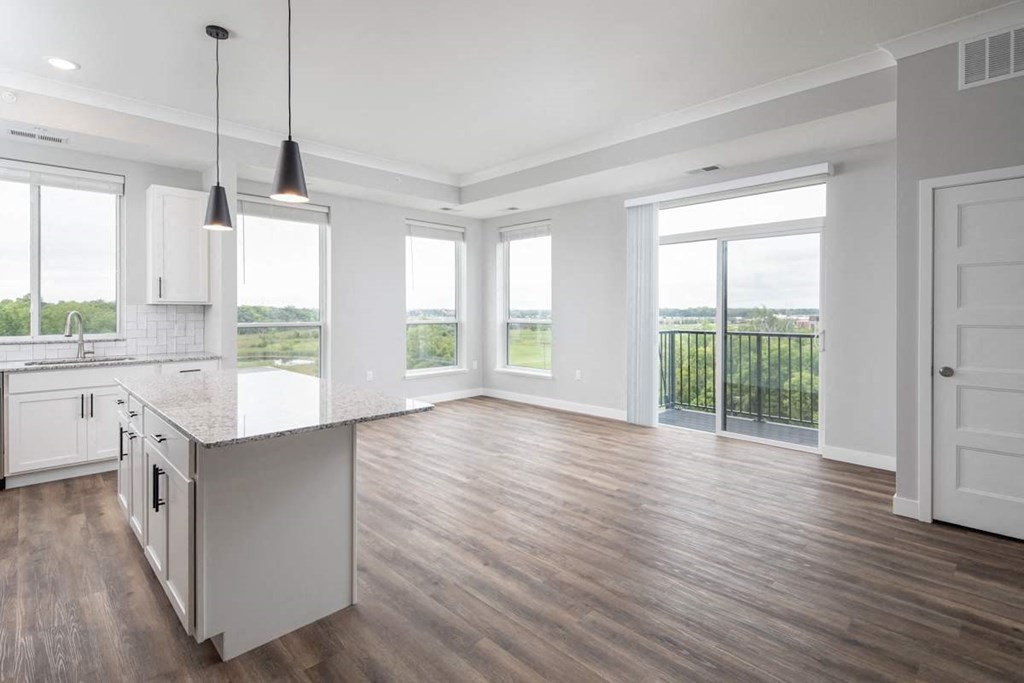 A kitchen with white cabinets and a wooden floor.at The Edison at Maple Grove, Maple Grove, MN