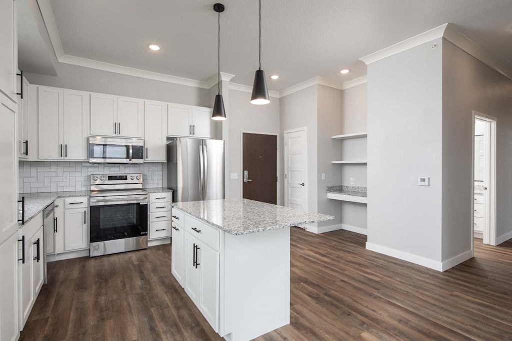 A kitchen with white cabinets and a wooden floor.at The Edison at Maple Grove, Maple Grove, 55311
