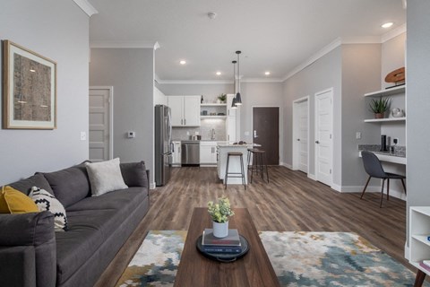A modern living room with a grey sofa and a wooden coffee table.