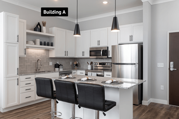 A modern kitchen with white cabinets and a center island.at The Edison at Maple Grove, Maple Grove Minnesota