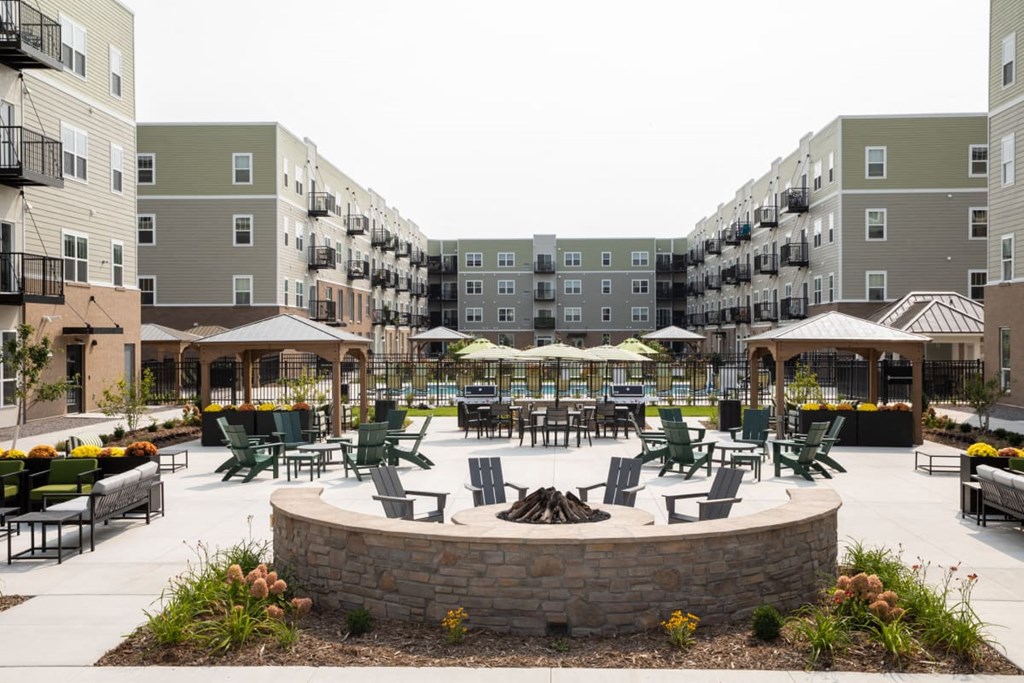 A courtyard with a fire pit surrounded by apartment buildings.at The Edison at Rice Creek I and II, Minnesota