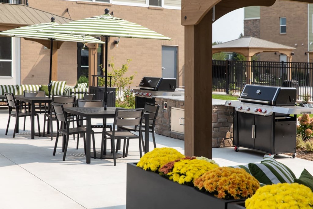 A patio with a table, chairs and a grill at The Edison at Rice Creek I and II, Shoreview, MN 55126