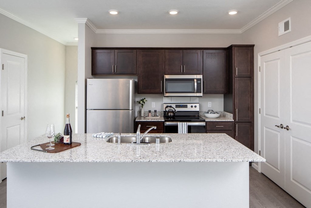 A kitchen with a white counter top and brown cabinets.at The Edison at Rice Creek I and II, Minnesota, 55126