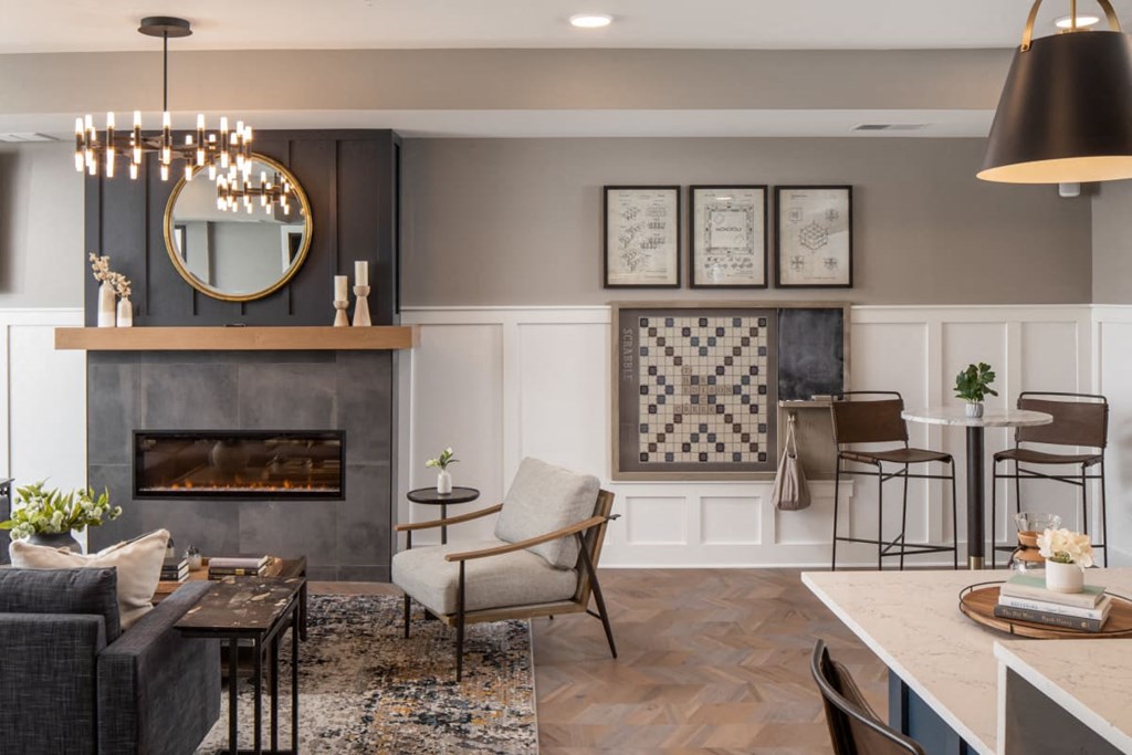 A modern living room with a fireplace and a chandelier at The Edison at Rice Creek I and II, Shoreview