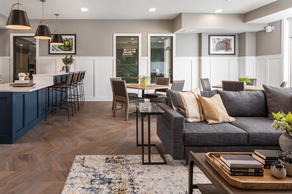 A modern living room with a grey sofa, a wooden coffee table, and a rug on the floor at The Edison at Rice Creek I and II, Shoreview Minnesota