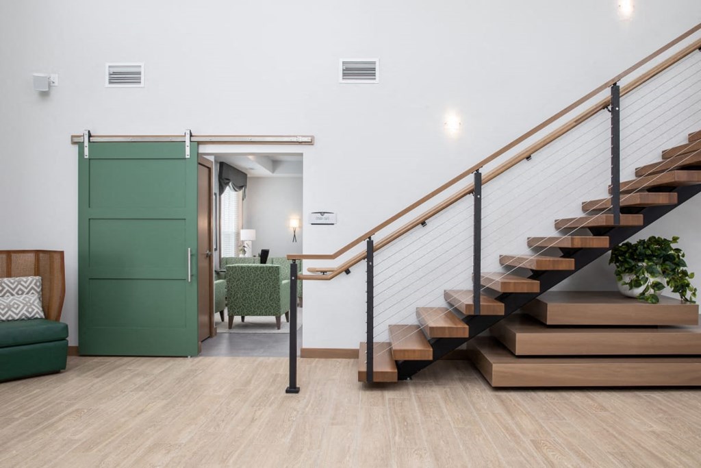A woman is walking up a wooden staircase.at The Edison at Rice Creek I and II, Shoreview, 55126