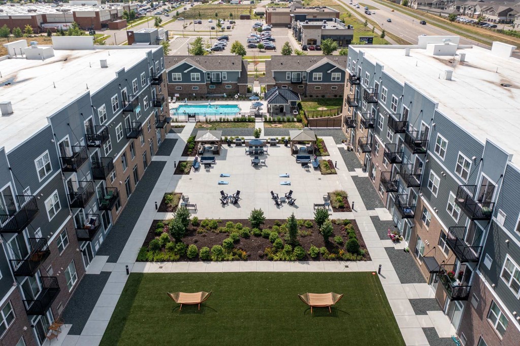 A view of a courtyard with a pool and apartment buildings at The Edison at Spirit, Minnesota