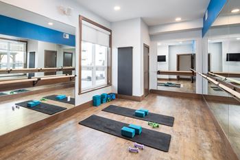 A yoga studio with mats and blocks on the floor at The Edison at Spirit, Minnesota, 55044