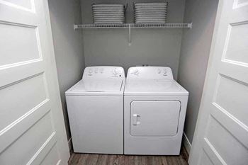 A white washer and dryer in a small laundry room at The Edison at Spirit, Shoreview
