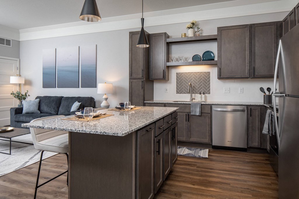 A modern kitchen with dark wood cabinets and stainless steel appliances at The Edison at Woodbury, Woodbury, MN 55129
