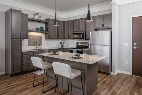 A kitchen with a table and chairs.