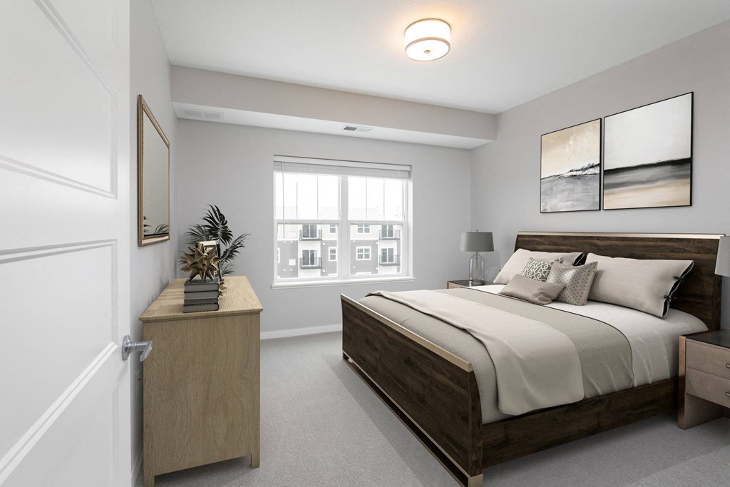 A bedroom with a large bed and a wooden nightstand at The Edison at Woodbury, Woodbury Minnesota