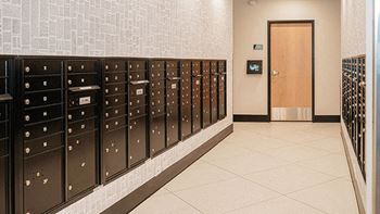 A hallway with a row of mailboxes on the wall at The Bessemer at Seward Commons Apartments, Minneapolis
