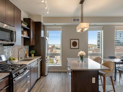 A modern kitchen with dark wood cabinets and a white countertop.