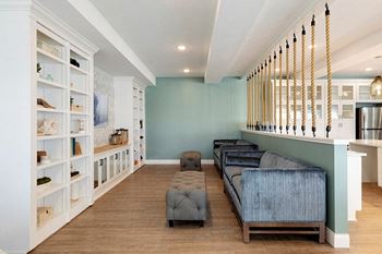A living room with a blue couch and a white bookshelf at The Barnum Apartments, MN, 55110