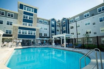 A swimming pool in front of a multi-story apartment building at The Barnum Apartments, Minnesota