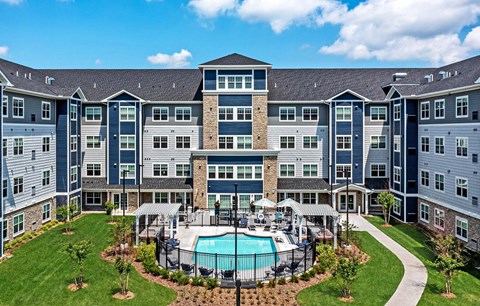 A large apartment complex with a pool in the middle of the courtyard at The Barnum Apartments, Minnesota