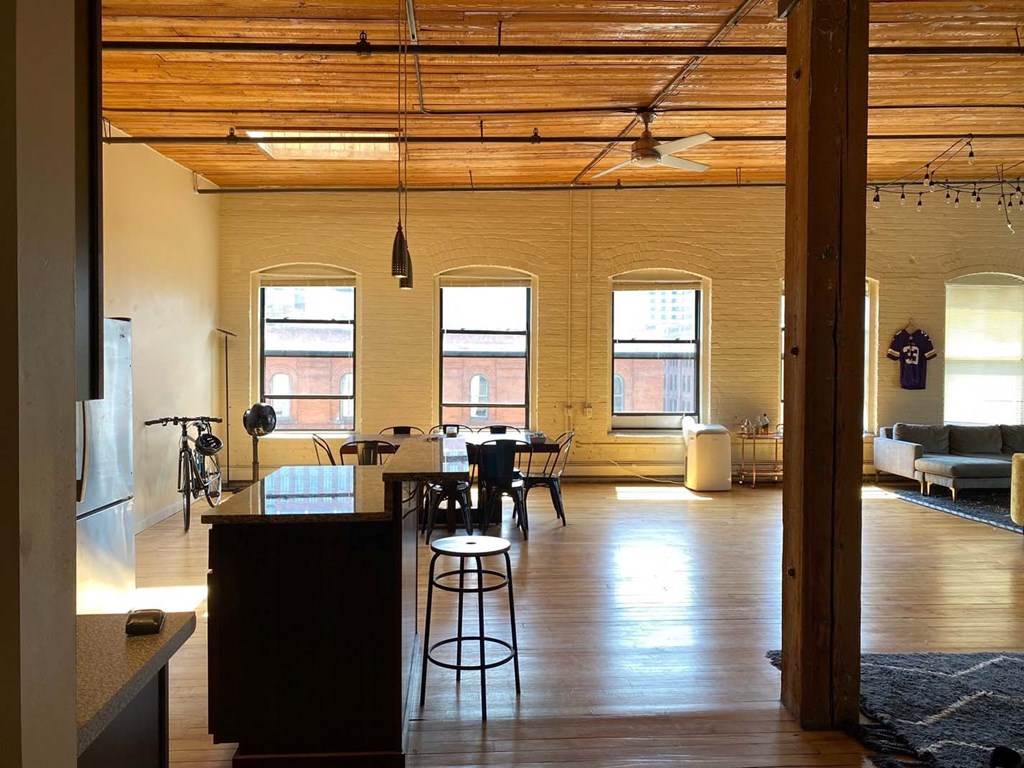 A kitchen with a bar stool and a table with chairs.at Lee Lofts, Minneapolis, MN 55401