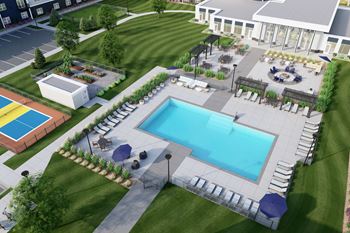 A pool surrounded by a grassy area with a building in the background at Lochner Apartments, Minnesota