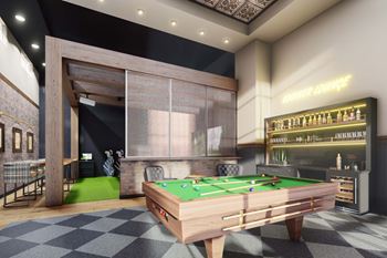 A pool table is in the middle of a room with a bar in the background at Lochner Apartments, Minnesota, 55110