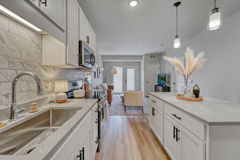 A kitchen with a sink and a microwave.