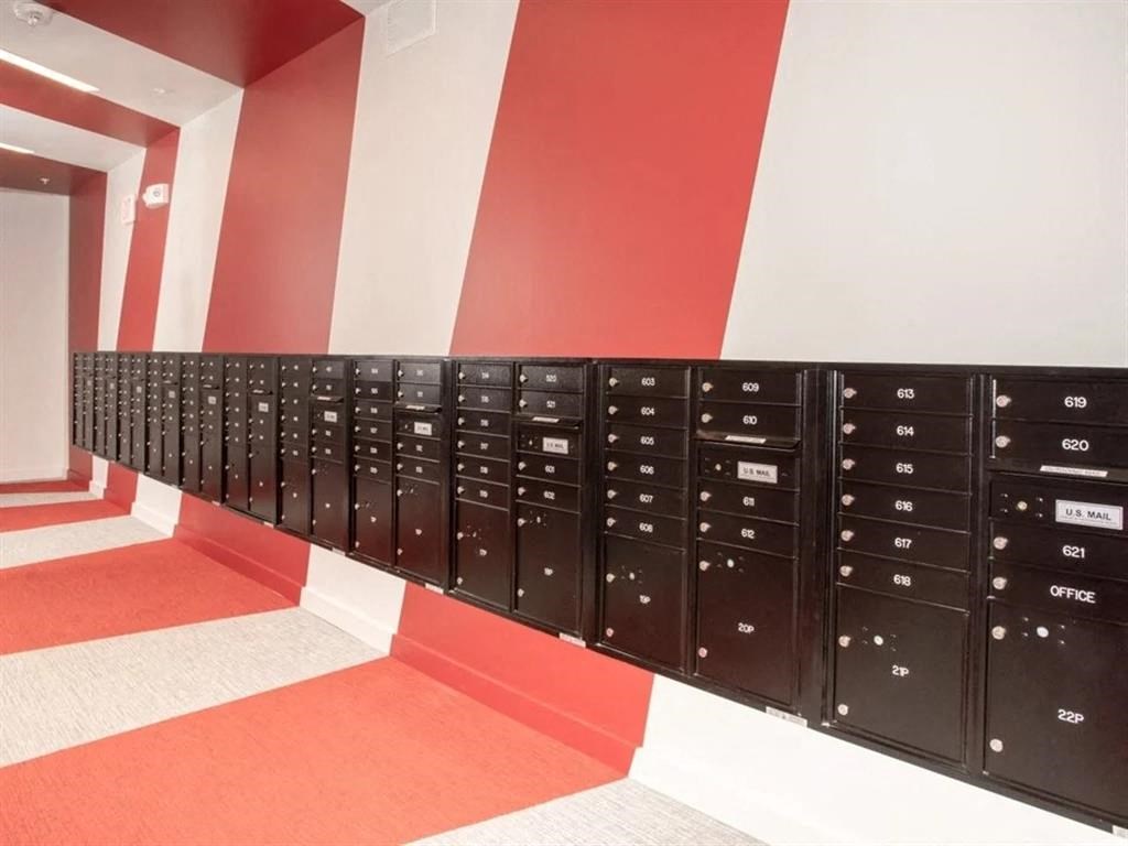 A long row of mailboxes are lined up on a wall.