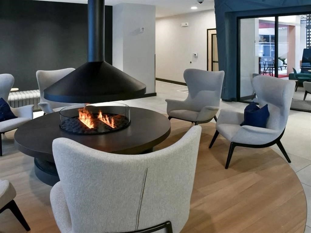 A modern living room with a fireplace and chairs.