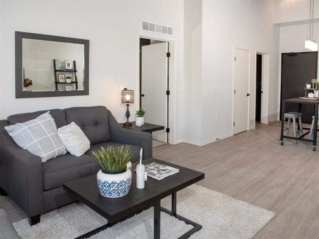 A grey couch with a white pillow is in the living room.