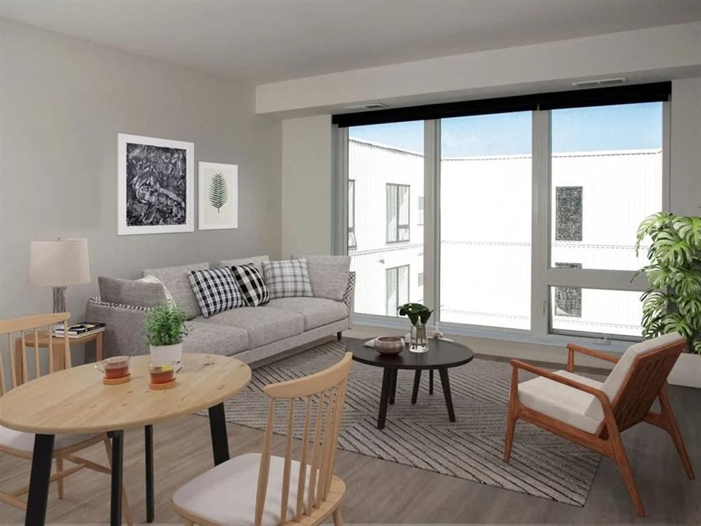A living room with a grey couch, a wooden table, and a chair.