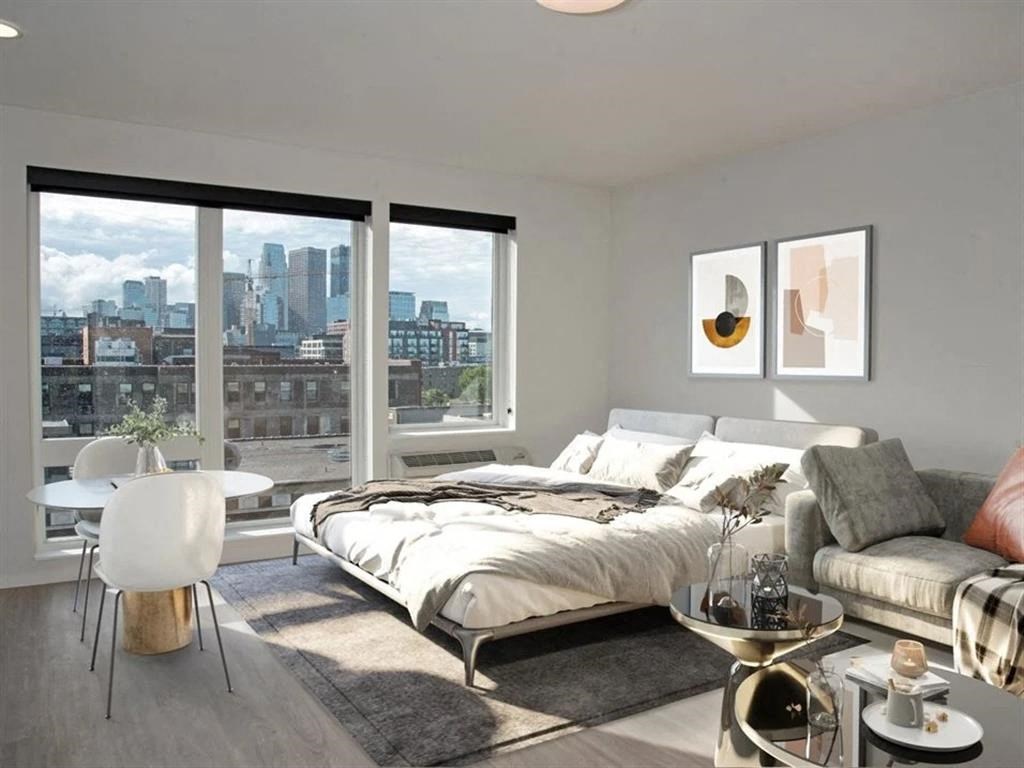 A bedroom with a large bed and a view of the city.