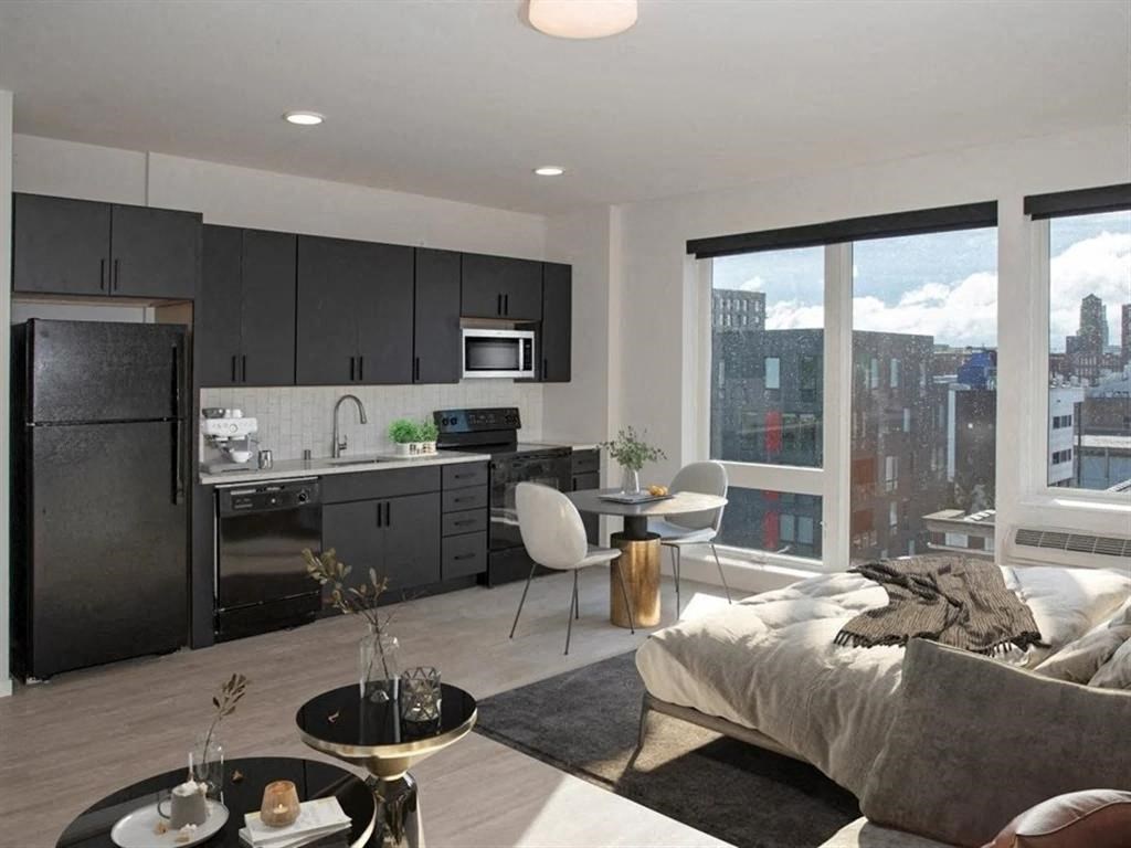 A modern kitchen with a dining area and a view of the city.